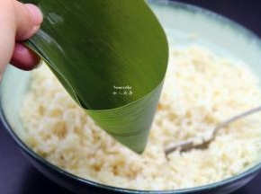 洗净干净的粽叶折叠成漏斗形状，但不能漏；