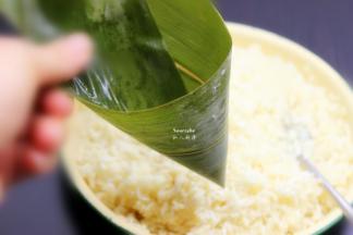 洗净干净的粽叶折叠成漏斗形状，但不能漏；