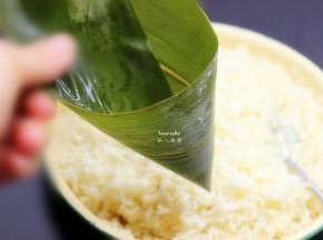 洗净干净的粽叶折叠成漏斗形状，但不能漏；