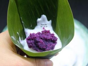 洗净干净的粽叶折叠成漏斗形状，放入拌均好的米糊和紫薯馅，包裹成自己喜欢的形状；