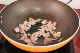 锅中留少许油，放入切好生姜、鸡腿肉爆炒；