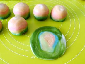 两头的面团将切口面朝下放擀大，之后包裹上莲蓉蛋黄馅，这样包裹的蛋黄酥才会层次感强，层次分明