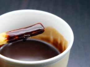 巧克力酱加入至50度，乘热，均衡的把1/2手指饼裹上巧克力酱；