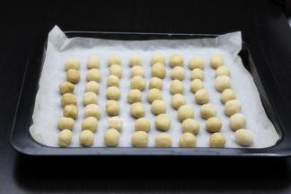 烤盘垫上硅油纸，把做好的花生小圆放入烤盘；