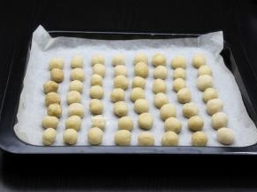 烤盘垫上硅油纸，把做好的花生小圆放入烤盘；