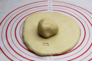 油酥面团放在擀开的油皮面团上，压扁，用擀面杖压一压，均匀的铺在油皮上；