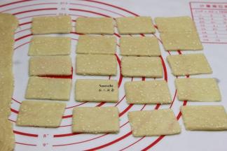 切除边角，然后切成小长方块，并用叉子在面片上扎小孔；