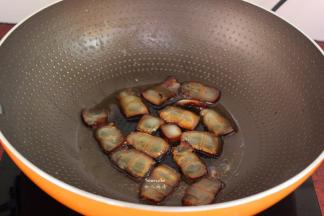 热锅，倒油，小火煎切片的腊肉至透明状起锅；