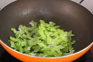 煎锅腊肉的锅中有油，倒入苦瓜爆炒；