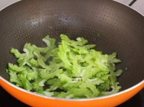 煎锅腊肉的锅中有油，倒入苦瓜爆炒；