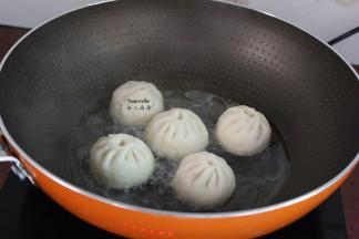 热锅，放油，放入包子，倒入适量的清水；PS：水量是包子高度的三分之一。