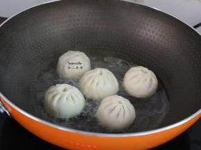 热锅，放油，放入包子，倒入适量的清水；PS：水量是包子高度的三分之一。