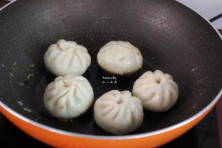 水干之后，再包子上面淋上花生油，小火煎至微黄；