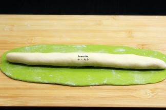 把原味面团揉成长条，放在菠菜面团中，卷起来；