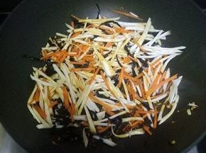 倒入杏鲍菇丝，木耳丝，胡萝卜丝炒软
