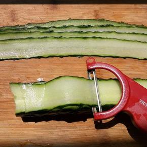 选一个直一些的黄瓜洗干净，去掉两端，用刮皮器刮成片状