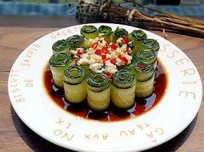 将调好的料汁浇在黄瓜上，蒜末和红辣椒段摆放在黄瓜上