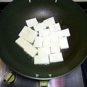 炒锅里倒适量油，油热后将豆腐一片一片放入锅中，小火慢慢煎