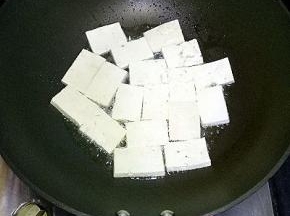 炒锅里倒适量油，油热后将豆腐一片一片放入锅中，小火慢慢煎