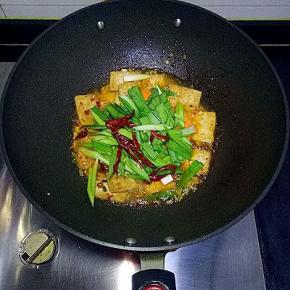 加入胡萝卜，青蒜苗，红辣椒翻炒均匀，大火收汁，加入适量鸡精翻炒均匀即可