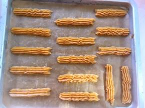 搅拌好的面糊装入裱花袋，我用的8齿裱花嘴，烤盘铺油纸，挤出长条