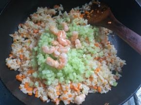 米饭全部炒热，翻炒均匀。加入黄瓜丁和虾仁翻炒均匀，出锅装盘即可。