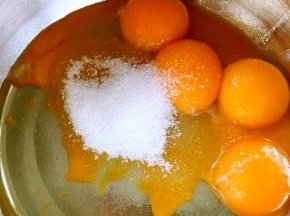 鸡蛋分离至干净容器，蛋黄加30克砂糖玉米油搅拌均匀