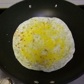 饼上打入一个鸡蛋，摊均匀，烙至鸡蛋半凝固时翻面在接着烙完全凝固时取出