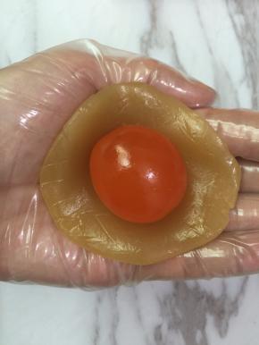 7. 醒面的过程可以准备馅料的部分
把莲蓉和蛋黄一起称出35克
莲蓉压成片把蛋黄包起