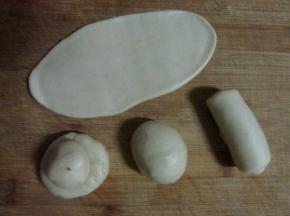 用水油皮包裹油酥，包严实后擀成长片，然后卷起来。全部做好后，再重复做一遍擀开卷起来。