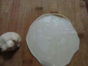 卷了两遍的酥皮对折，然后擀成圆片，厚度大约1毫米多点