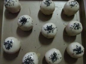 包好收口朝下放入烤盘，表面刷蛋液，撒少许黑芝麻