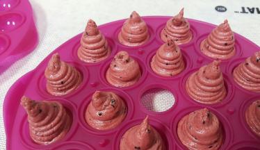 用裱花袋将面糊挤入模具当中，挤成如图所示的样子，上面要高出来一些，这样才会满模，这个配方的量正好是一个乐葵模具的量