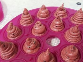 用裱花袋将面糊挤入模具当中，挤成如图所示的样子，上面要高出来一些，这样才会满模，这个配方的量正好是一个乐葵模具的量