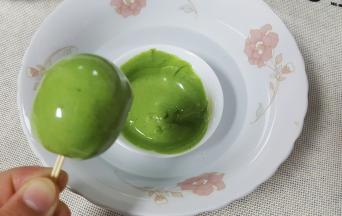 另取一个碗，将巧克力隔水融化，加入适量的抹茶粉或油溶性色素，将裏好白巧克力的棒棒糖，在绿色巧克力液中转一圈做成西瓜皮