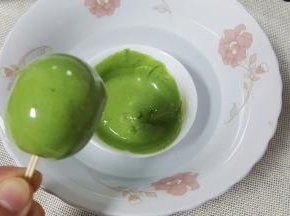 另取一个碗，将巧克力隔水融化，加入适量的抹茶粉或油溶性色素，将裏好白巧克力的棒棒糖，在绿色巧克力液中转一圈做成西瓜皮