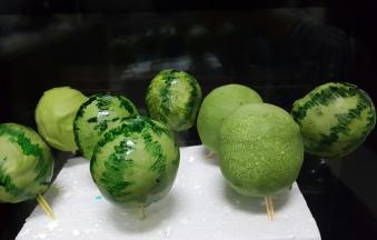 当巧克力液完全凝固以后，取适量可食用色素，用绿色色素用笔蘸赞赏画出西瓜的纹路，这样小西瓜就做好了