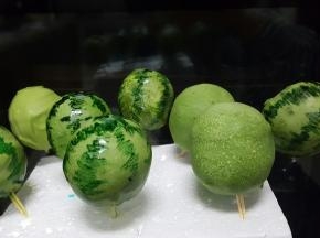 当巧克力液完全凝固以后，取适量可食用色素，用绿色色素用笔蘸赞赏画出西瓜的纹路，这样小西瓜就做好了