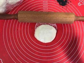 用擀面杖将叠好的饺子皮擀大两圈