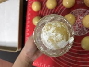 模具里面撒些面粉再磕出来，防粘
月饼团四周抹上点面粉，面团放入模具中间，压出花纹