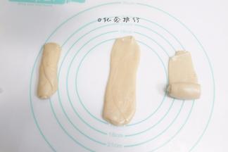 把醒好的卷卷压扁再擀一次，这次擀的不要太窄，而且越规整越好，最好是矩形，先中间擀一下，再朝上擀一下朝下擀一下，不要来回擀挤压油酥，然后卷起来，