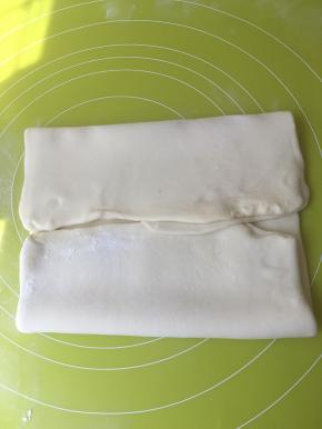 四个角向中间折，把黄油全部包裹在面团里，擀成长方形，之后两边向中间在对折