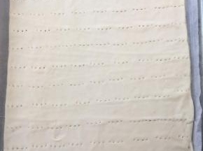 裁掉不规则的边角，盖保鲜膜松弛半个小时，烤箱预热180度，将松弛好的面团连底下的油纸一起放入烤盘，烤半个小时，表面焦黄，出炉凉透备用