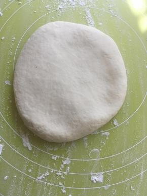 松弛好的面团从冰箱取出，面垫上撒点干粉，从中间往外擀成长方形，要中间厚一点，四周薄一点