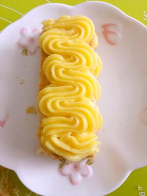 在挤好的卡士达酱上铺一块千层酥，中间的可以用切碎的，这样做出来不影响美观，之后再挤上一层卡士达酱