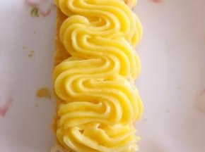 在挤好的卡士达酱上铺一块千层酥，中间的可以用切碎的，这样做出来不影响美观，之后再挤上一层卡士达酱