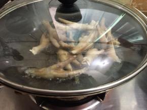 6. 锅里坐油烧热倒入鸡爪盖上盖子（以防溅油）