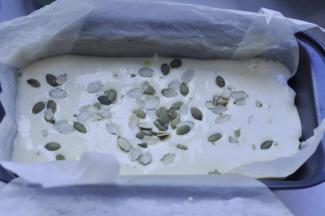 10、将完全混合均匀的蛋糕糊，从20CM高度倒入垫有油纸的模具，在蛋糕糊面上撒上南瓜子。