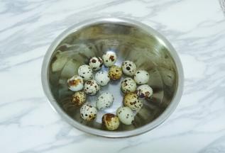 将鹌鹑蛋放入小盆中，用清水清洗干净表面