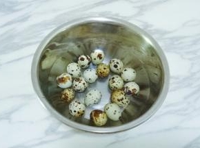 将鹌鹑蛋放入小盆中，用清水清洗干净表面